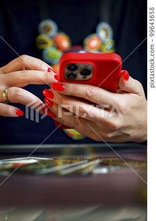 Future and online divination. A fortune teller does online fortune telling on photos from a smartphone. Future and online divination. A fortune teller does online fortune telling on photos from a smartphone. 99643658