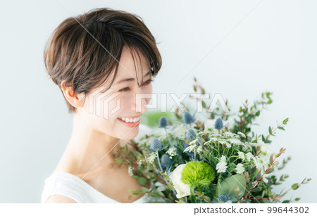 A woman in her 40s with a bouquet A woman in her 40s with a bouquet 99644302