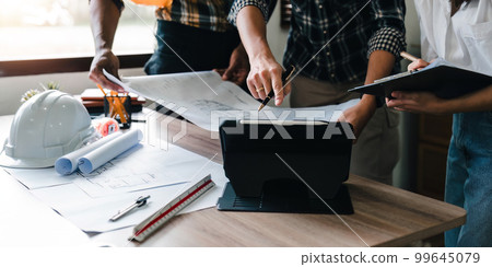 People adviser construction site engineers. working drawing on blueprint and discussing the floor plans over blueprint architectural plans at on digital tablet. construction concept 99645079