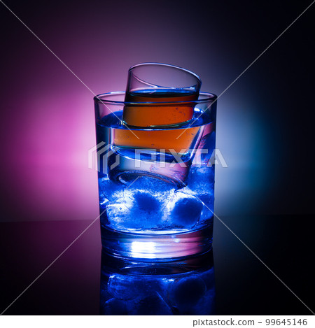 A shot glass with liquor and ice 99645146