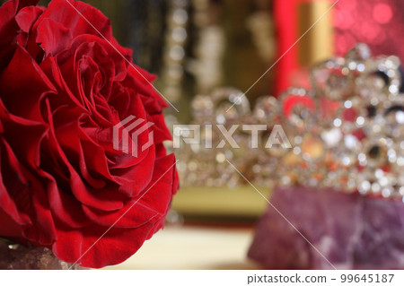 Rose and Tiara with Perfume and Jewelry in Background 99645187