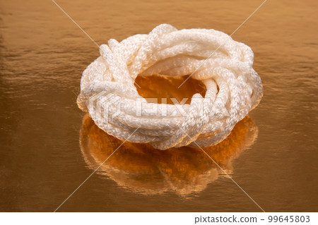 rope made of synthetic material on a golden background rope made of synthetic material on a golden background 99645803