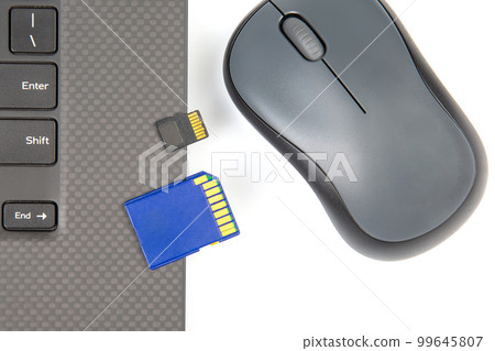 sd memory card for recording electronic data near a laptop on a white background 99645807