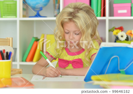 little girl studying at home at the table 99646182