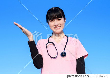 A female nurse wearing a scrub standing with the blue sky in the background Medical staff doctor Examination Pointing recommended Trimming up A female nurse wearing a scrub standing with the blue sky in the background Medical staff doctor Examination Pointing recommended Trimming up 99646723