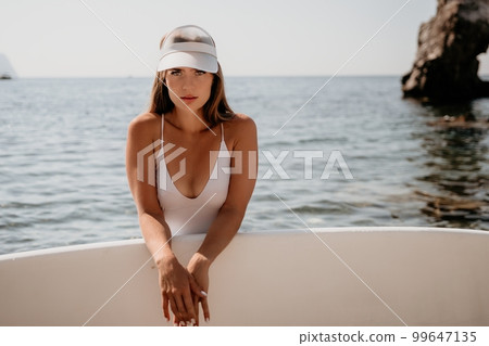 Woman sea sup. Close up portrait of happy young caucasian woman with long hair looking at camera and smiling. Cute woman portrait in a white bikini posing on sup board in the sea 99647135