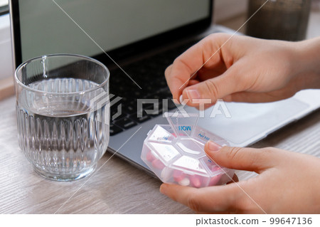 Woman sorting pills Organizer weekly shots Closeup of medical pill box with doses of tablets for daily take medicine with white pink drugs and capsules. Young woman getting her daily vitamins at home Woman sorting pills Organizer weekly shots Closeup of medical pill box with doses of tablets for daily take medicine with white pink drugs and capsules. Young woman getting her daily vitamins at home 99647136