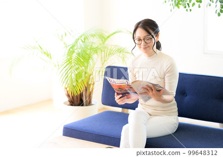 一位戴眼鏡的女士一邊看小冊子一邊思考 99648312