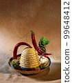 abstract composition assembled from a Mexican hat, hot pepper, wire and cacti 99648412