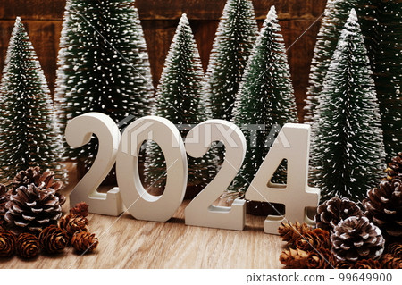 Happy New Year 2024 festive background with christmas tree and pine cone decoration on wooden background Happy New Year 2024 festive background with christmas tree and pine cone decoration on wooden background 99649900