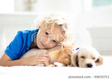 Child, dog and cat. Kids play with puppy, kitten. 99650751