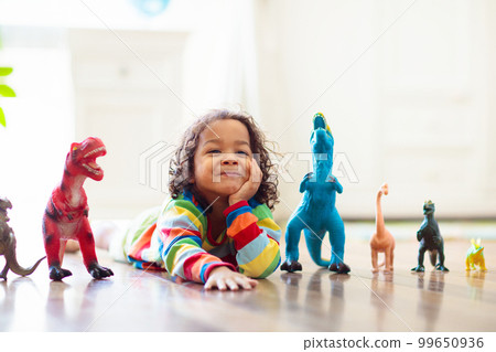 Child playing with toy dinosaurs. Kids toys. Child playing with toy dinosaurs. Kids toys. 99650936