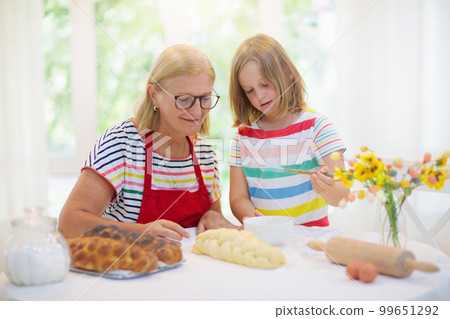 Mom and child baking bread. 99651292