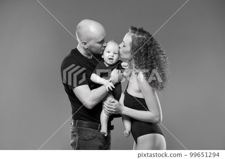 Young family with small child. Dad holds his son mom gently kisses him. Family Young family with small child. Dad holds his son mom gently kisses him. Family 99651294