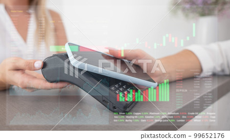 Close-up of a woman paying with a smartphone. Stock charts on a virtual screen. Close-up of a woman paying with a smartphone. Stock charts on a virtual screen. 99652176