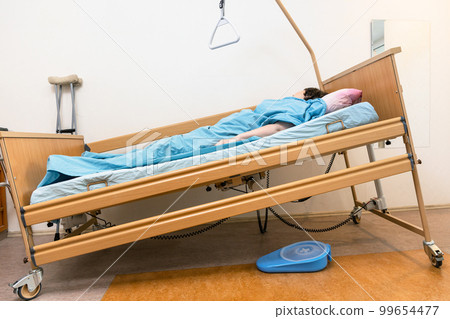 sloped electric hospital bed with patient at home 99654477