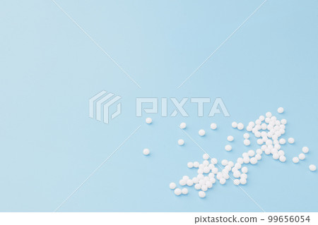 Homeopathic globules scattered on a blue background. Alternative Homeopathy medicine. Homeopathic globules scattered on a blue background. Alternative Homeopathy medicine. 99656054