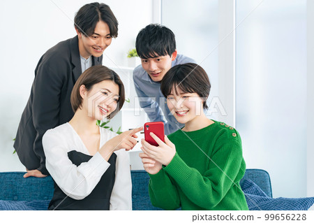 A group of young men and women gathering to look at their smartphones Generation Z 99656228