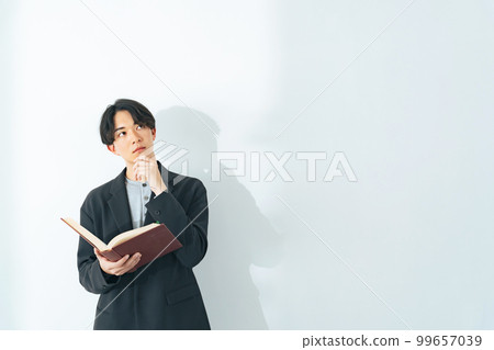 Portrait of a young man with a book Portrait of a young man with a book 99657039
