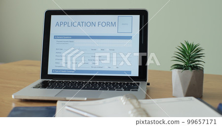 Laptop computer with an Application Form on its display. 99657171