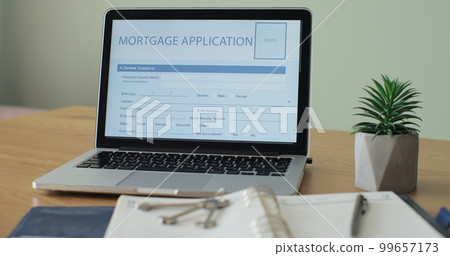 Online Mortgage Application showing on a laptop computer screen on a desk. 99657173