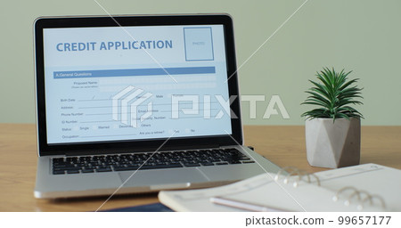 Online Credit Application form showing on a laptop computer screen sitting on a desk. 99657177