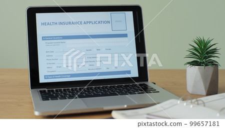 Online Health Insurance Application showing on a laptop computer screen sitting on a desk. Online Health Insurance Application showing on a laptop computer screen sitting on a desk. 99657181