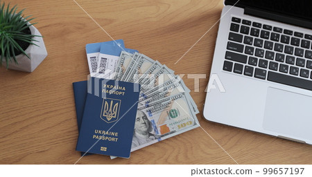 Tourist stuff with passport, money and tickets on wooden background desk with laptop computer. Top view. 99657197