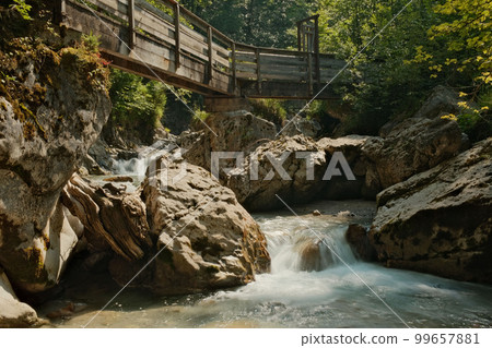 Wooden bridge over the Seisenbergklamm gorge in Weissbach bei Lofer, Austria with jagged rocks around 99657881