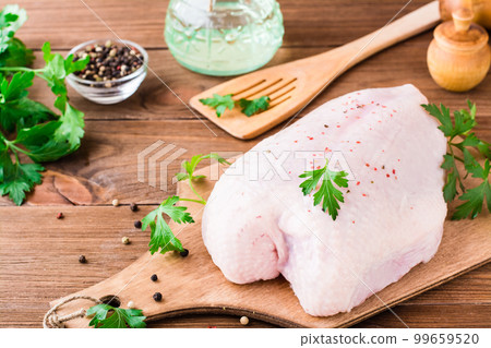 Raw chicken breast on a frame in spices and herbs on a cutting board on a wooden table Raw chicken breast on a frame in spices and herbs on a cutting board on a wooden table 99659520