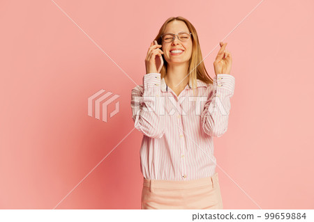 Young pretty blonde girl, businesswoman wearing modern office style clothes talking on mobile phone over pink background. 99659884