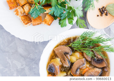 Homemade mushroom soup with champignons, fresh herbs and breadcrumbs. Top view Homemade mushroom soup with champignons, fresh herbs and breadcrumbs. Top view 99660013