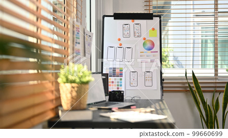 Creative office with laptop, stationery and wireframe sketches of screens for mobile application on a flip board Creative office with laptop, stationery and wireframe sketches of screens for mobile application on a flip board 99660699