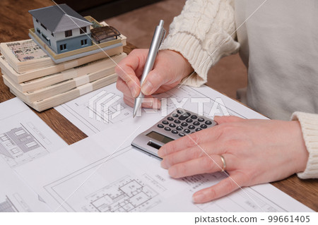 [A housewife doing calculations for purchasing a home] 99661405