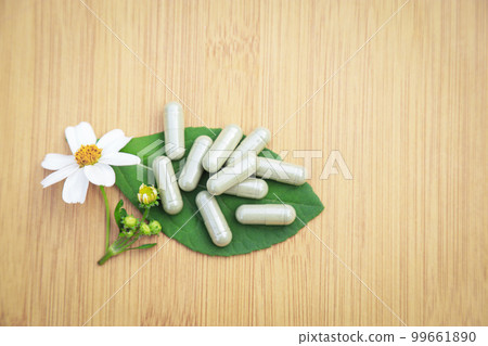 Herbal medicine in capsules from herb leaf on rustic wooden table with copy space for medical background. healthy eating with natural product for good living. Herbal medicine in capsules from herb leaf on rustic wooden table with copy space for medical background. healthy eating with natural product for good living. 99661890
