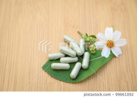 Herbal medicine in capsules from herb leaf on rustic wooden table with copy space for medical background. healthy eating with natural product for good living. Herbal medicine in capsules from herb leaf on rustic wooden table with copy space for medical background. healthy eating with natural product for good living. 99661892