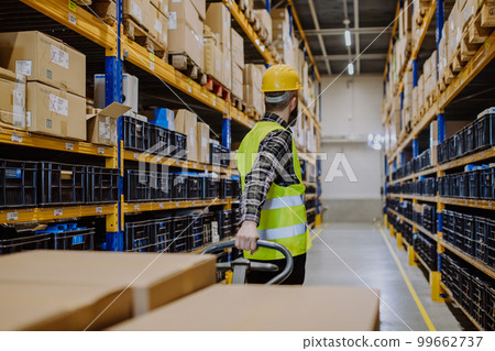 Male warehouse worker dragging a pallet truck. Male warehouse worker dragging a pallet truck. 99662737