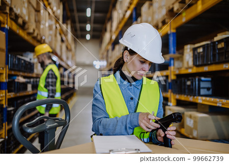 Warehouse female worker checking up stuff in a warehouse. Warehouse female worker checking up stuff in a warehouse. 99662739