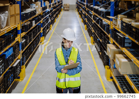 Warehouse female worker checking up stuff in a warehouse. 99662745