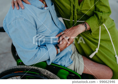 Close-up of senior man on wheelchair enjoying together time with his wife at sea. 99662946