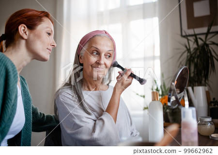 Senior woman making make up herself at home. 99662962