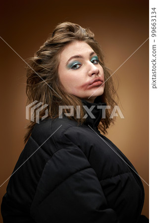 portrait of woman with smudged lipstick and in black jacket on beige background. portrait of woman with smudged lipstick and in black jacket on beige background. 99663134
