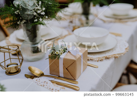High angle view of wedding gift wrapped in eco paper papckaging and flower decoration. High angle view of wedding gift wrapped in eco paper papckaging and flower decoration. 99663145