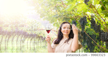 Beautiful woman dreaming tasting red wine enjoying summer stay in vineyards on lovely sunny day Beautiful woman dreaming tasting red wine enjoying summer stay in vineyards on lovely sunny day 99663323