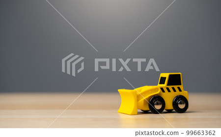 The yellow bulldozer toy. Construction works. Clearing and leveling the land. Building destruction. Take down Illegal construction. Industry The yellow bulldozer toy. Construction works. Clearing and leveling the land. Building destruction. Take down Illegal construction. Industry 99663362