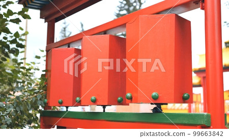 Rotation of the red prayer drums outside the Buddhist temple. 99663842