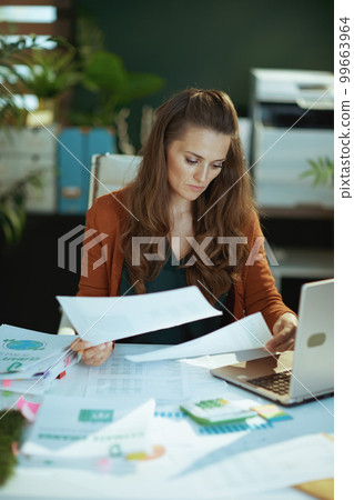 business owner woman in green office working with documents 99663964