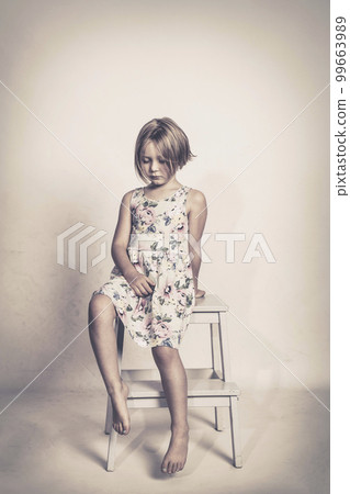 sad little girl sits on a stool sad little girl sits on a stool 99663989
