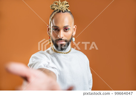 Black latin gay man outstretching empty hand towards camera 99664047