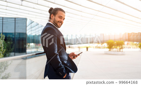 Businessman standing outdoor use smartphone 99664168